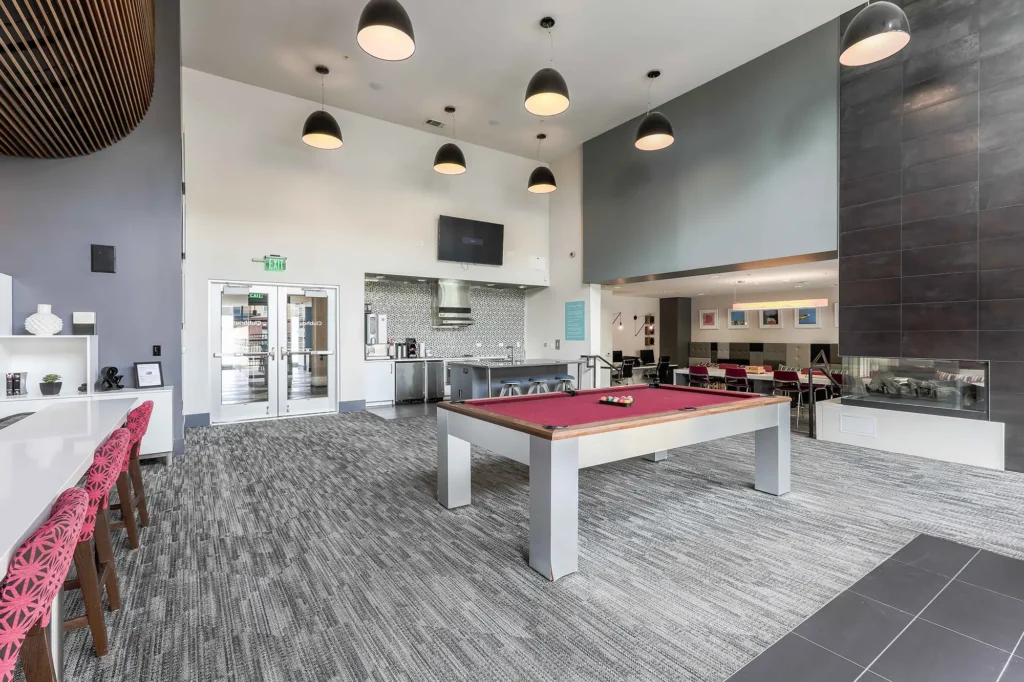 Clubhouse game room with pool table and kitchen
