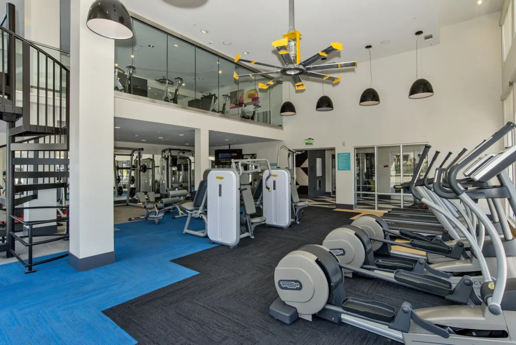 Fitness center with strength training equipment, cardio machines, and free weights